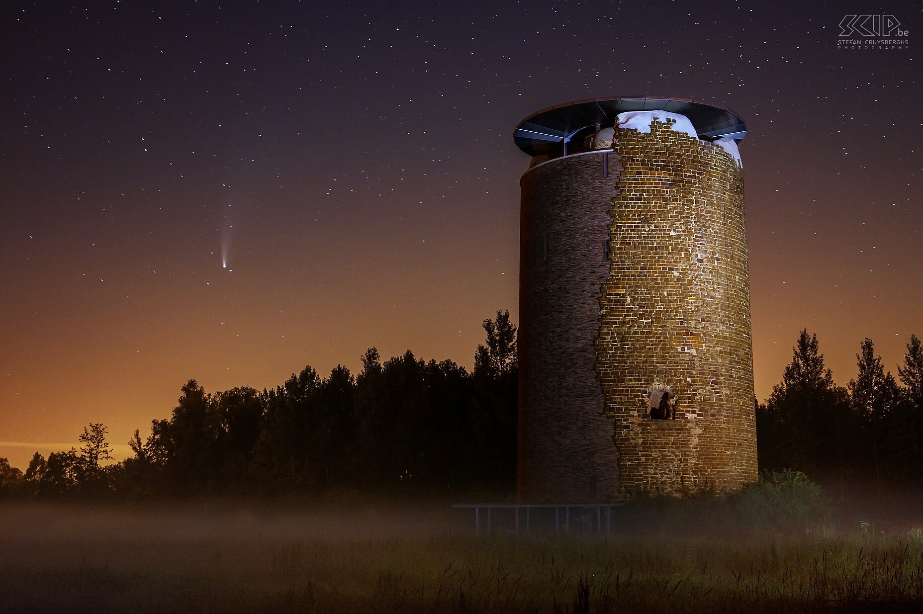 Hageland by night - Maagdentoren met komeet NEOWISE In Juni 2022 was het mogelijk om komeet NEOWISE met z’n lichtgevende staart te zien aan de sterrenhemel. Ik trok naar de Maagdentoren in onze stad Scherpenheuvel-Zichem om er wat foto’s te maken. Aan de horizon links zie je komeet NEOWISE. Met zak- en LED lamp heb ik de toren trachten te belichten. Nu is het weer 6800 jaar wachten totdat we de komeet nog eens kunnen waarnemen.<br />
 Stefan Cruysberghs